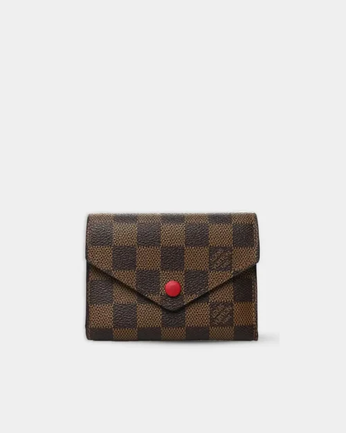 Victorine wallet in damier ebene coated canvas with red snap closure, front view.